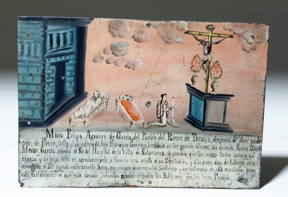 20th C. Mexican Tin Ex-Voto, Hospitalized Mother & Son: Latin America, Mexico, ca. early 20th century CE. An antique Mexican ex-voto painting depicting a woman named Maria Felipa Aguirre de Garcia and her son, both sick in bed, at center, the hospital they