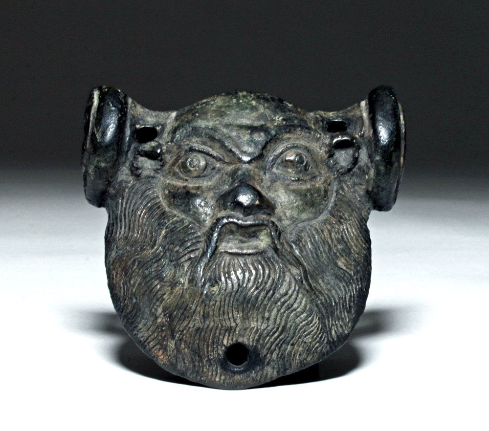 Lg Roman Bronze Handle Attachment - Silenus: Rome, ca. 0 CE. This is a heavy bronze handle attachment molded in the face of Silenus, the tutor/follower of Dionysus, always depicted as an older man with a large, full beard. This particular piece
