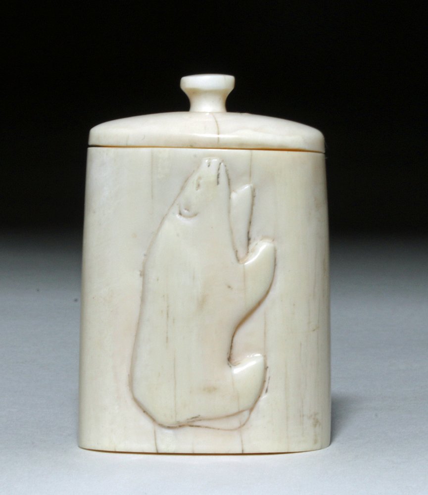 Early Inuit Carved Whale's Tooth - Bear on Box: Inuit, ca. 20th century CE. This is a charming small box with a handled lid and a profile-view polar bear carving in relief. This box was made in the traditional Inuit style using a hand axe and file.