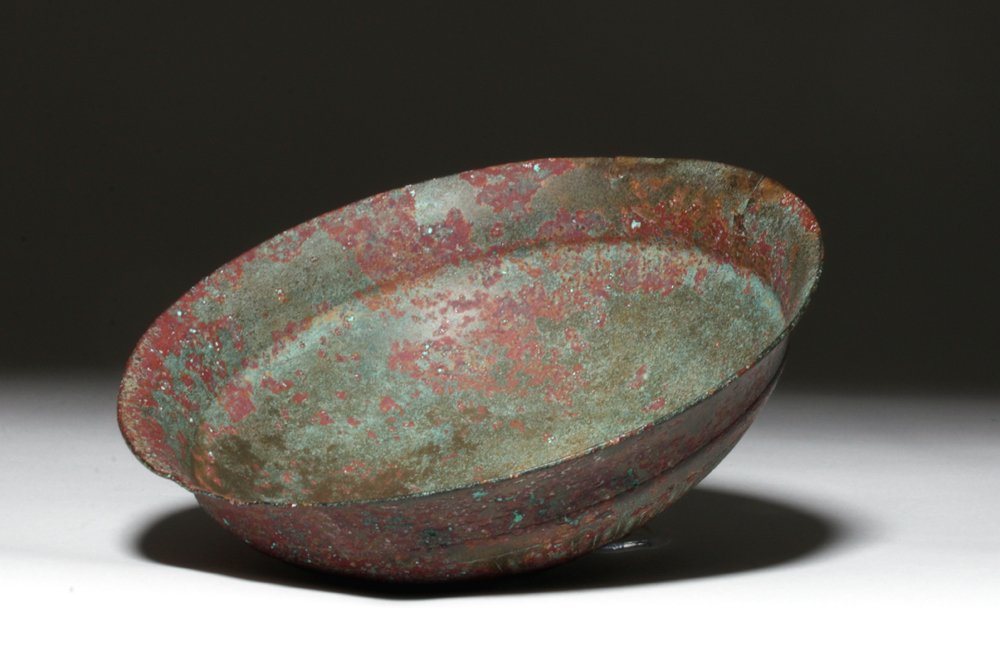 Luristan Bronze Bowl w/ Ribbed Base, ex-Piscopo: Luristan, Modern day Iran, ca. 1000 to 650 BCE. This is a cast bronze bowl with a single indented line around its interior lip, a design of concentric circles at its base, and a radiating design on it