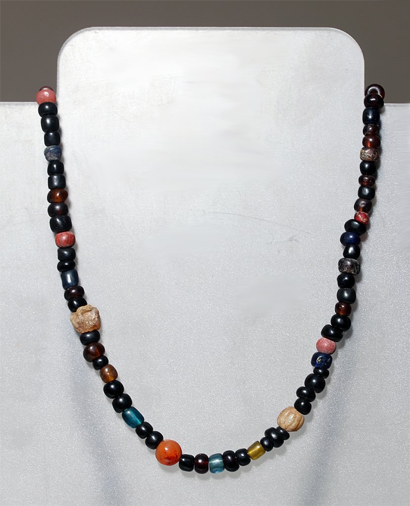 Ancient Roman Glass / Stone Bead Necklace: Roman Empire, and later periods, ca 100 to 1900 CE. Necklace comprised of dozens of ancient Roman glass and stone beads interspersed with more modern glass beads. Colors vary from deep blue to carneli