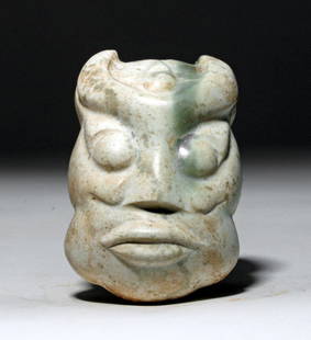 Chinese Shang Dynasty Jade Maskette, ex-Arnovick: China, Shang Dynasty, ca. 1558 to 1046 BCE. This is a gorgeous mostly white jade (nephrite) mask with a pale green stripe of the mineral going down its face. The features include wide, staring eyes