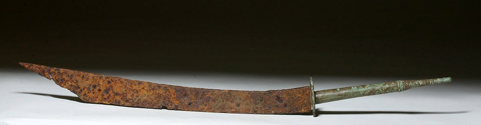 Desirable Khmer Bronze / Iron Sword, ex-Piscopo: Far East, Cambodia, Khmer Empire, ca. 12 to 13th century CE. A wonderful bronze and iron sword! Blade made of iron with upcurved blade and angled tip, attached to decorated guard and long thin grip en