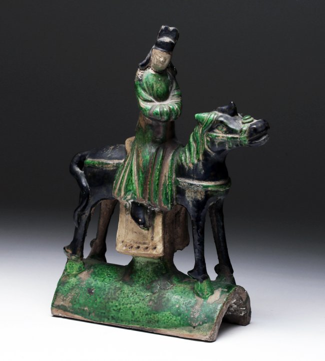 Chinese Ming Dynasty Roof Tile, ex-Lupita Tovar: Asia, China, Ming Dynasty, ca. 1368 to 1644 CE. A glazed, earthenware ornamental roof tile adorned with a man, perhaps a prince or warrior, who dons an emerald-green hued robe and is mounted upon a de