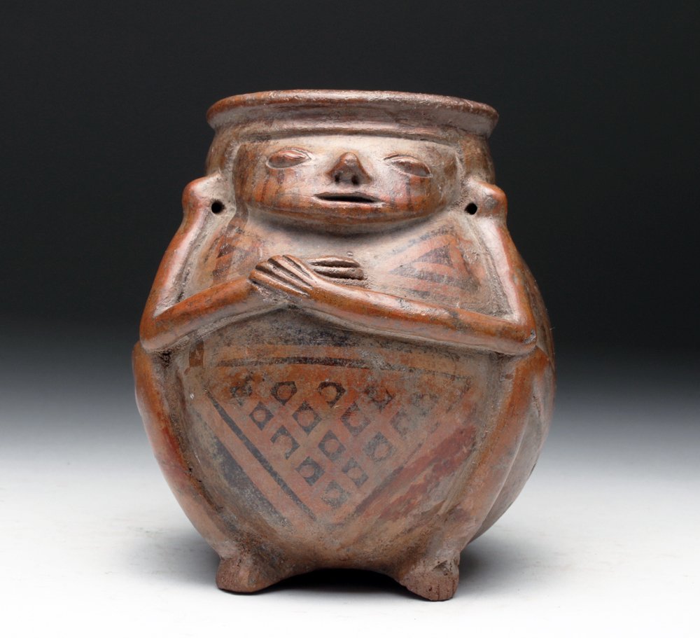 Narino Pottery Figural Jar w/ Ear Perforations: Pre-Columbian, Colombia, Narino, Capuli Complex, ca. 850 to 1500 CE. Lovely pottery jar in the form of a seated human, hands to their chest, body wonderfully decorated in negative resist. Size: 5.5" L