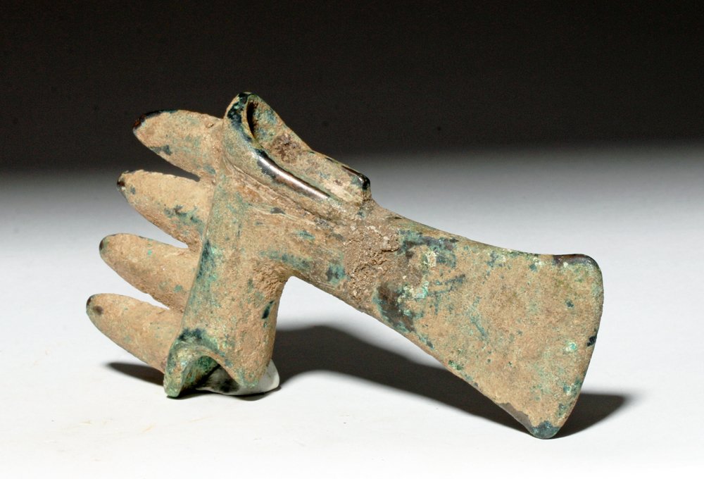 Ancient Luristan Bronze Axe, ex-Piscopo: Luristan, modern-day northwestern Iran, ca. 1000 BCE. This is a beautiful example of the classic Luristan-style lost wax cast bronze axe. It has four arrow-shaped flares, a small hollow cylindrical so