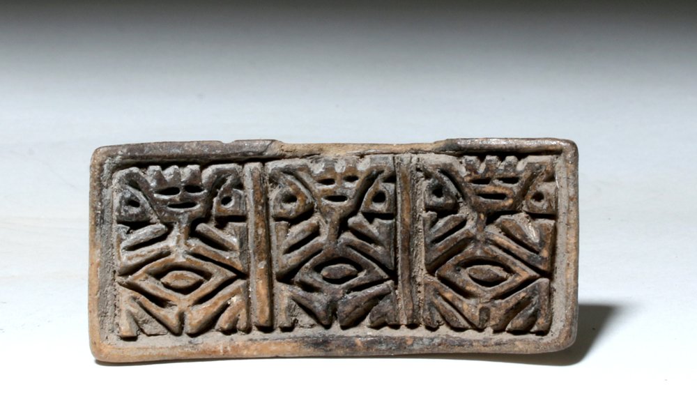 Pre-Columbian La Tolita / Tumaco Pottery Stamp: Pre-Columbian, Colombia, La Tolita/Tumaco, ca. 500 BCE to 500 CE. An ancient pottery stamp with an intricately detailed design depicting three nearly identical abstract figures, each one squatting wit