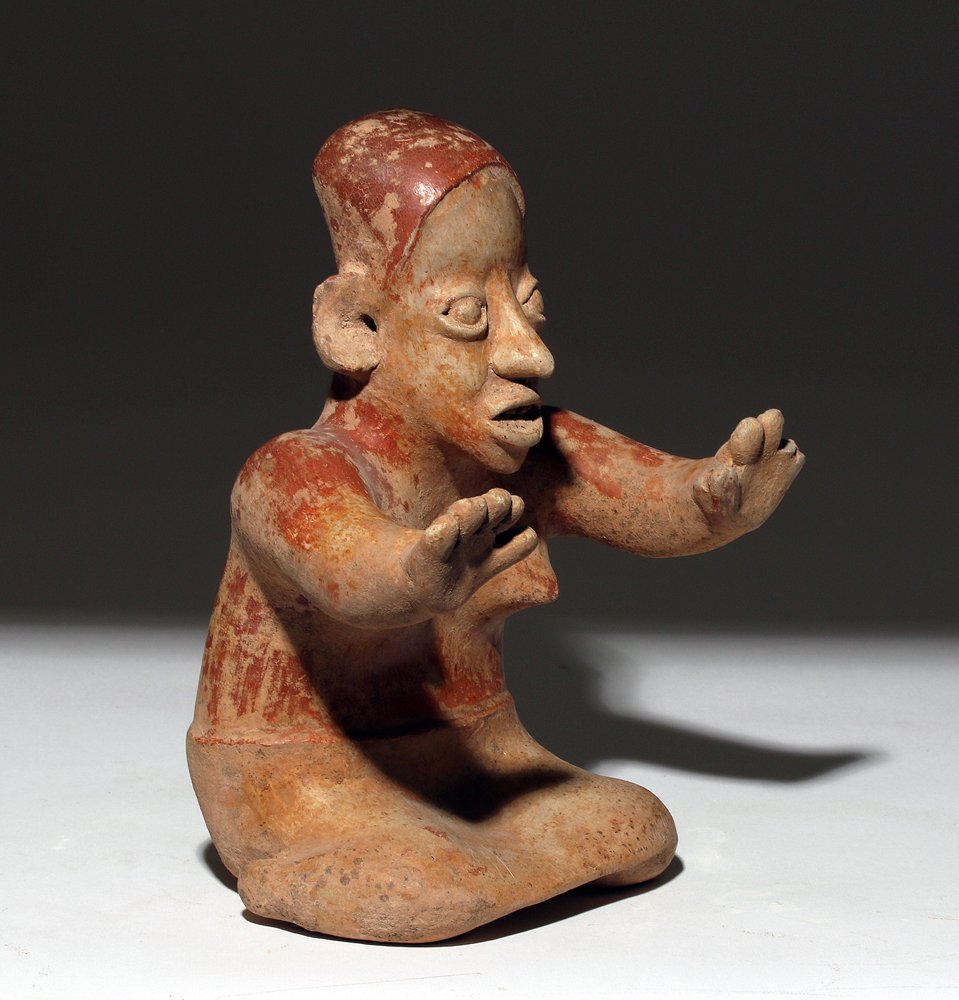 Jalisco Clay Kneeling Female Figure: Pre-Columbian, West Mexico, Jalisco, ca. 300 BCE to 300 CE. This is a hollow pottery figure of a kneeling female with her hands outstretched as if imploring the viewer to stop. Unlike many Jalisco fig