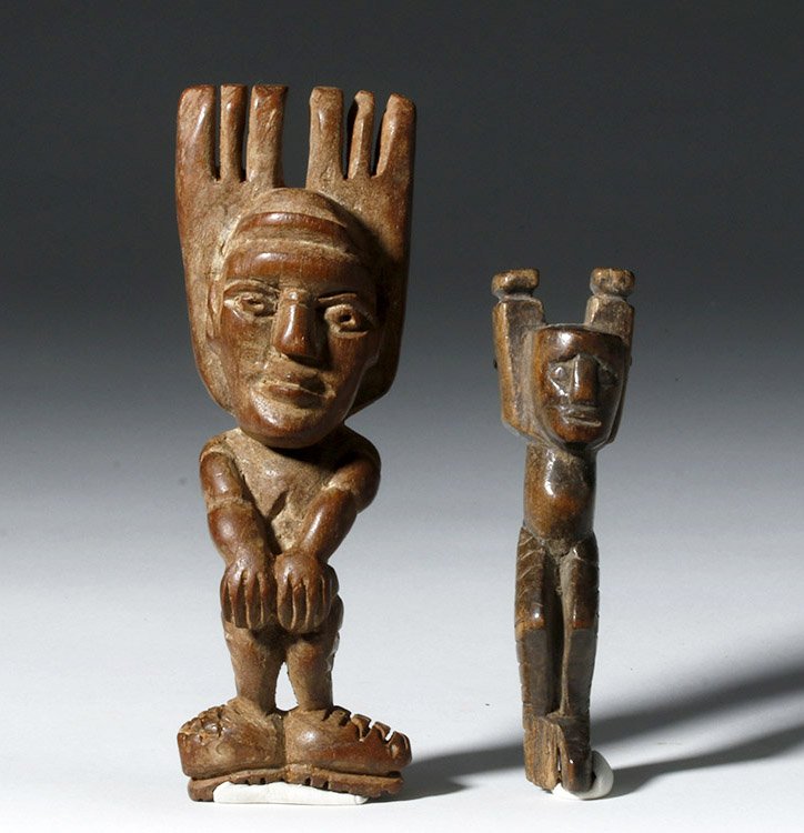 Pair Antique Guatemalan Wood Slingshots, ex-Historia: Central America, Guatemala, ca. mid-20th century CE. A pair of hand carved wooden slingshots depicting human figures (perhaps prisoners), the larger one presenting both muscular arms and finely deline