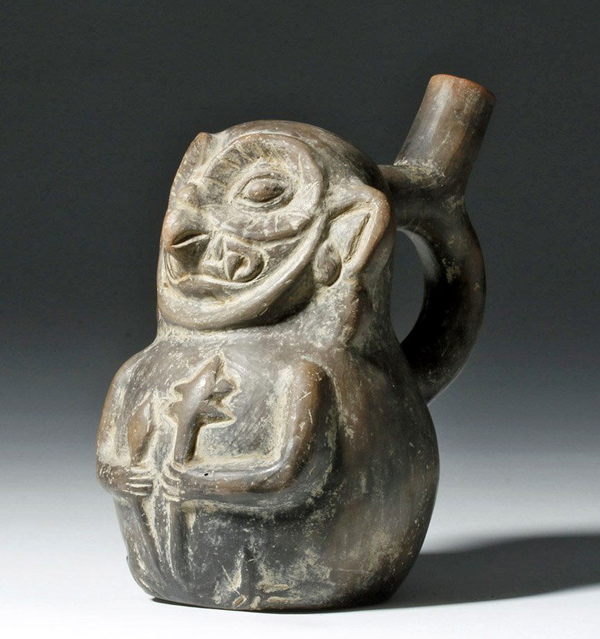 Chimu Brownware Stirrup Vessel - Owl Warrior: Pre-Columbian, Peru, Chimu, ca. 900 to 1470 CE. A brownware stirrup vessel depicting a fierce owl warrior proudly presenting a pair of intimidating weapons, one in each talon, created by the Chimu cul