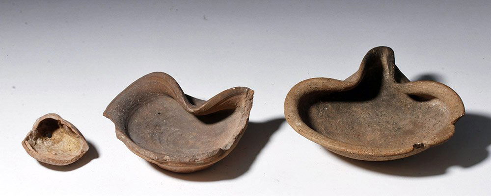 Pair Holy Land Oil Lamps + Roman Pottery Fragment: Near East, Holyland, Iron Age, ca. 1200 BCE. Two early buff terracotta oil lamps, the more pristine example of a rounded, almost bowl-like form with a pronounced pinched spout. Created and used in the