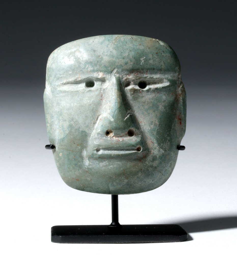 Miniature Olmec Jadeite Maskette: Pre-Columbian, Mexico, Olmec culture, ca. 10th to 6th century BCE. This is a beautiful miniature jadeite mask with a finely detailed, long, straight nose, narrowed eyes with drilled pupils, and a flat