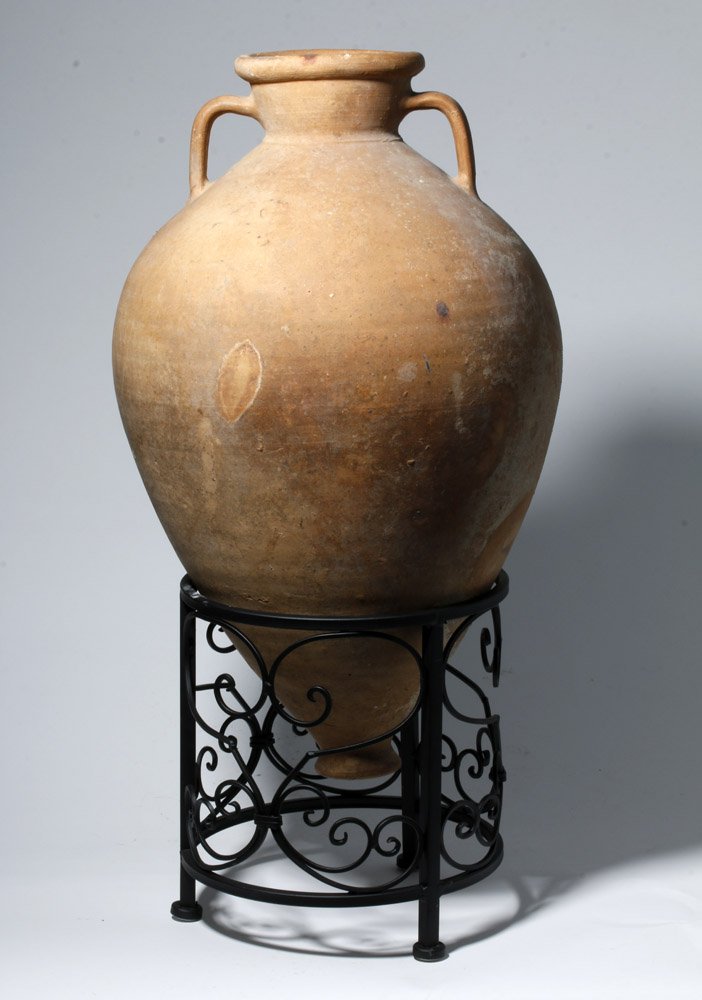 Intact Greek Hellenistic Terracotta Transport Amphora: Greece, Hellenistic Period, late 3rd to mid-2nd century BCE. This is a large, buff terracotta transport amphora. It has an ovoid body ending in a tip with a flat foot; twin long handles rise from the