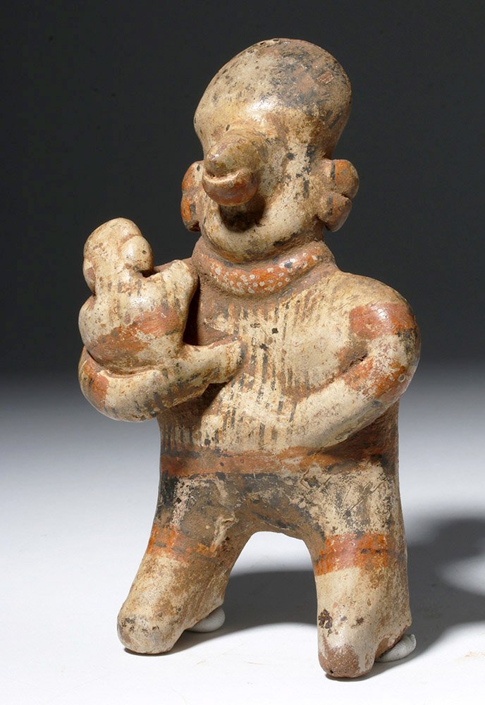Nayarit Polychrome Pottery Mother & Baby: Pre-Columbian, West Mexico, Nayarit, ca. 200 BCE to 200 CE. An endearing sculptural representation of a mother and child, decorated in red and black on a beige ground. The standing female holds her in