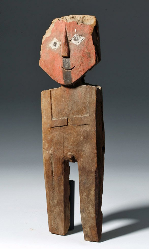 Chancay Painted Wood Standing Male Figure: Pre-Columbian, Peru, Central Coast, Chancay, ca. 900 to 1200 CE. A carved wooden standing male figure made from one piece with a typical mummy bundle face painted red with eyes comprised of black iris