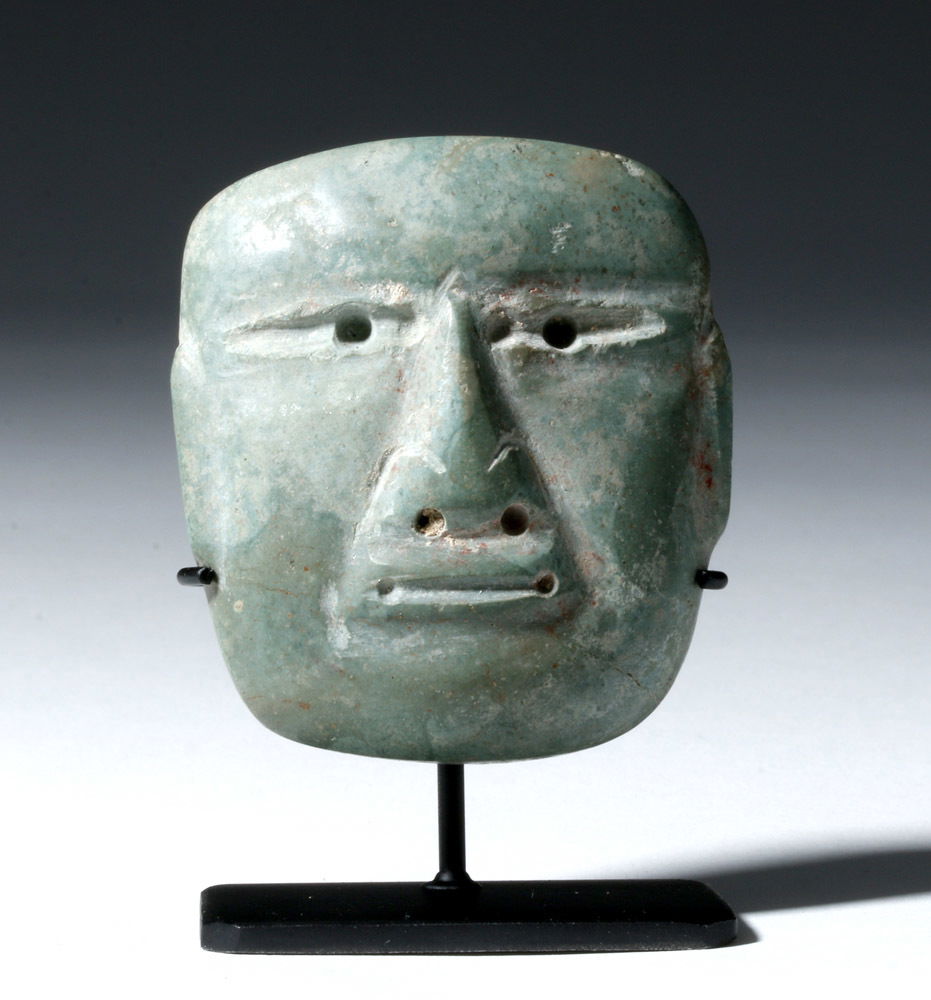 Miniature Olmec Jadeite Maskette: Pre-Columbian, Mexico, Olmec culture, ca. 10th to 6th century BCE. This is a beautiful miniature jadeite mask with a finely detailed, long, straight nose, narrowed eyes with drilled pupils, and a flat