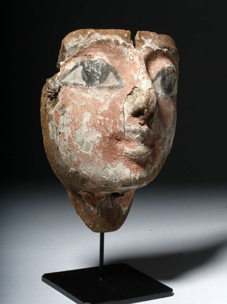Egyptian Wood & Gesso Child's Mummy Mask: Egypt, Late Period, ca. 712 to 300 BCE. This painted wooden sarcophagus mask displays quintessential Egyptian beauty - the huge, black outlined eyes, the smaller nose and mouth. It is an elegant and r