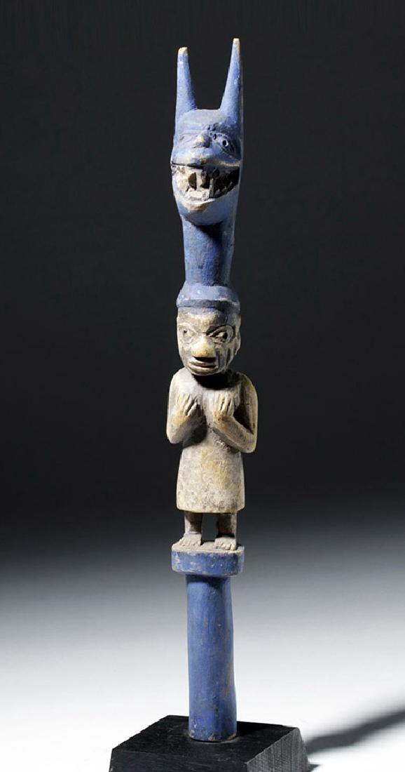 West Africa Yoruba Carved Wooden Totem: West Africa, Nigeria, Yoruba peoples, mid to late 20th century CE. A brightly painted wooden totem, hand-carved, with a woman who stands tall, holding her breasts and wearing a massive blue headdress.