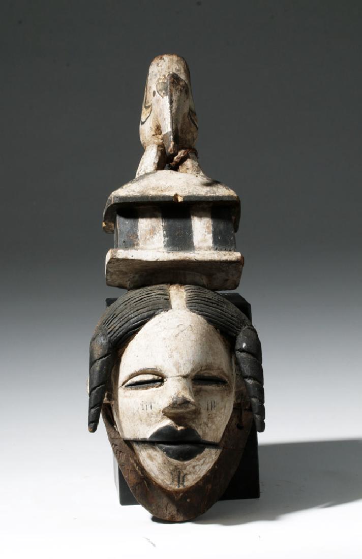 African Ogoni Carved Wood Mask - Hinged Jaw & Bird: Africa, Southeastern Nigeria, Ogoni, ca. early 20th century CE. A finely carved painted wood mask of the Ogoni culture who are known for their human faced masks with hinged, articulated jaws and inset