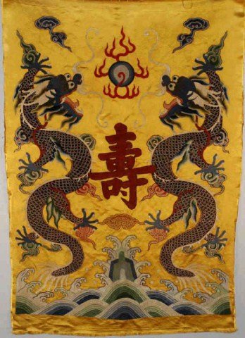 Chinese Embroidery: China, 19th century, depicting dragons and clouds on a yellow ground, in mid decorated with chinese Shou character for long live. 40" h x 27" Condition vg/g