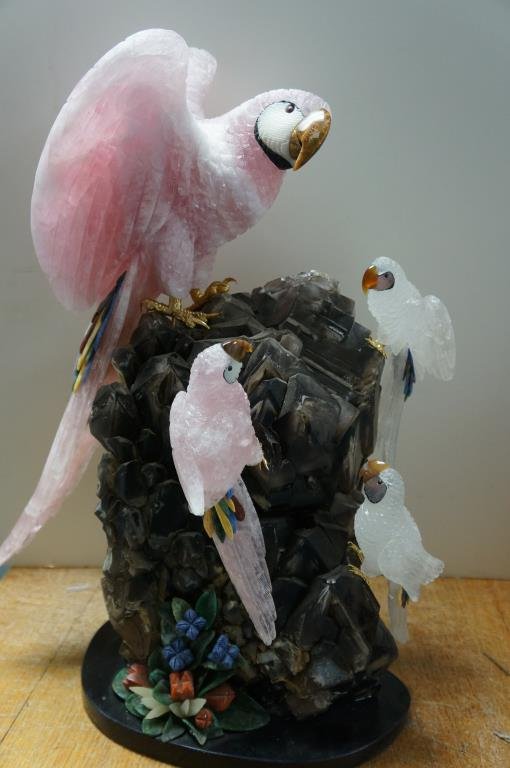 Smokey Quartz and Rose Quartz Rock Sculpture: large sculpture having 4 quartz parrots on Smokey quartz crystal with flower form stone formations. large pink parrot is carved from one 23 continues stone all expect beak 23" x 16" 3 parrots measure 