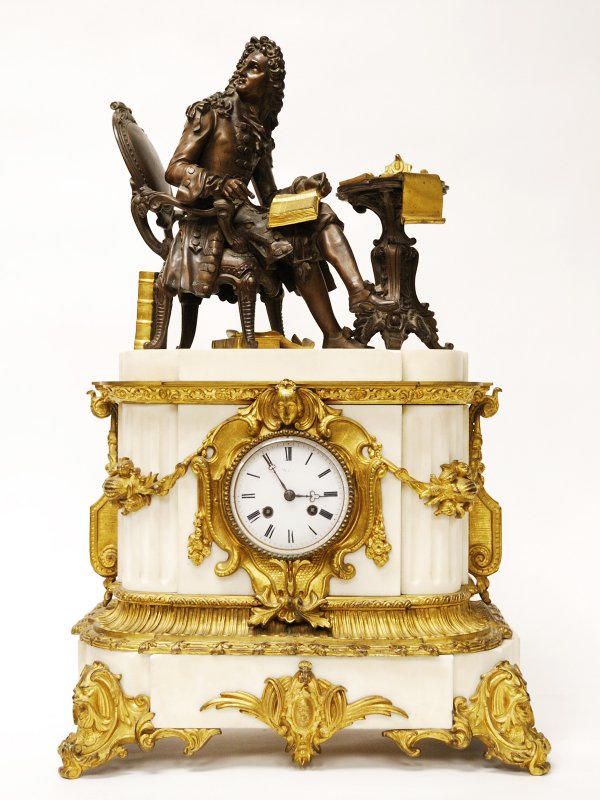 French Baroque Style Mantel Clock Bronze and Marble: French Baroque Style Marble and Bronze Dore Figural Mantel Clock, 19th Century, on top sits a bronze man 17th Century dress on a bronze chair at a bronze table surrounded by bronze dore books and scro