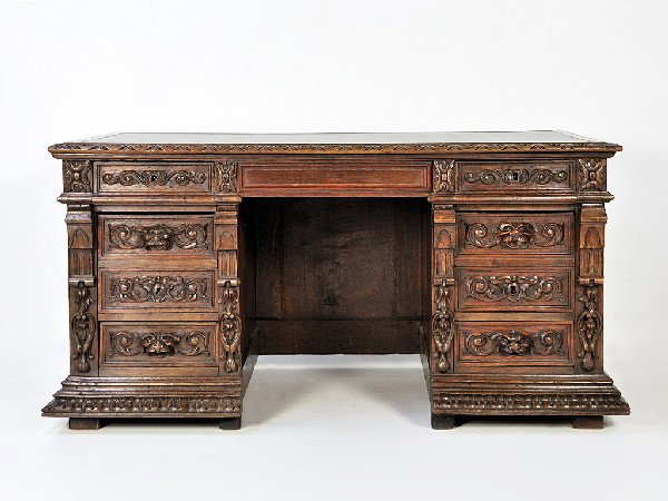 A GOTHIC OAK DESK France, Nineteenth Century: A GOTHIC OAK DESK France, Nineteenth Century The leather rectangular top, above three front panels featuring soldiers dressed in armor with three highly carved drawers on either side of the kneehole 3