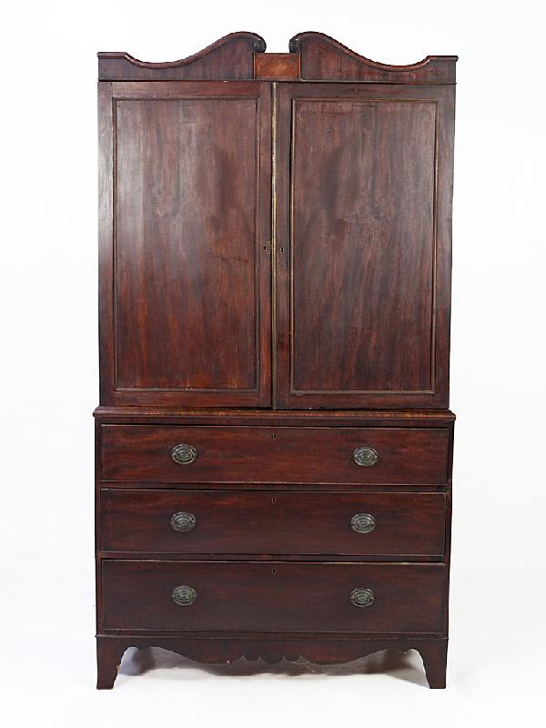 A FEDERAL STYLE MAHOGANY LINEN PRESS: A FEDERAL STYLE MAHOGANY LINEN PRESS having two doors and three drawers with brass oval handles 38 x 18 x 16 inches
