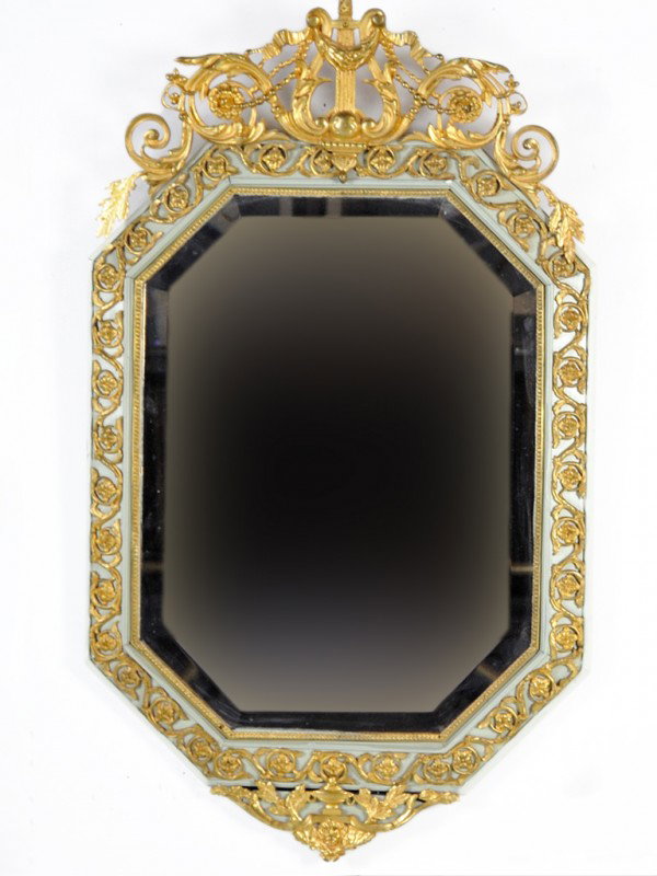 A BEVELED OCTAGONAL MIRROR WITH DORE BRONZE ORMULU : A BEVELED OCTAGONAL MIRROR WITH DORE BRONZE ORMULU Nineteenth Century with a harp and scroll design crest 41 x 24 x 1 1/2 inches