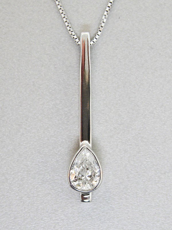 A CUSTOM DESIGN BY BILL HALL PEARSHAPE DIAMOND PEND: A CUSTOM DESIGN BY BILL HALL PEARSHAPE DIAMOND PENDANT 14K white gold stick pendant, measuring 1" inch in length, bezel set with one pearshape diamond=.52 Ct., I-Color Grade, SI2-Clarity Grade. Accomp