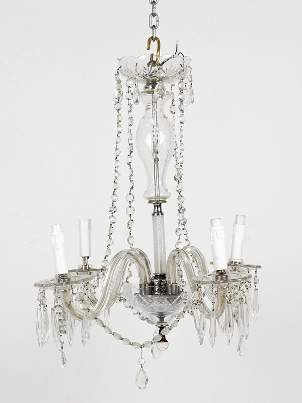 A FOUR LIGHT CRYSTAL CHANDELIER: A FOUR LIGHT CRYSTAL CHANDELIER with candle shaped fixtures, dangling faceted cut crystal briolettes and strands of small faceted round crystals 25 x 21 1/2 x 21 1/2 inches