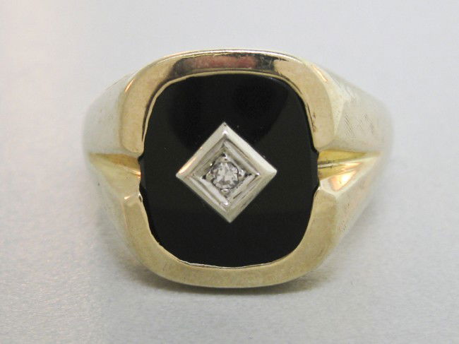 GENTLEMANS BLACK ONYX AND DIAMOND RING - Finger siz: GENTLEMANS BLACK ONYX AND DIAMOND RING - Finger size 12 ½ 10K yellow gold set with cushion shape black onyx with white gold plate in center set with a .02 Ct circular cut diamond. 8.2 grams.