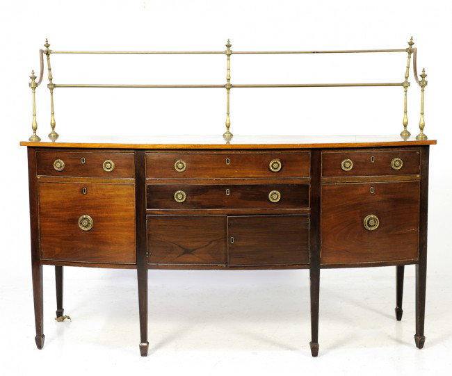 A SHERATON MAHOGANY BUFFET WITH BRASS GALLERY TOP: A SHERATON MAHOGANY BUFFET WITH BRASS GALLERY TOP with bowed front and brass handles 56 1/2 x 72 x 27 1/2 inches