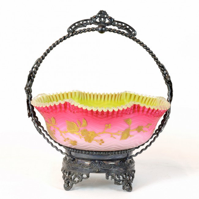 AN AMERICAN SILVERPLATE BRIDE'S BASKET WITH RUFFLED : AN AMERICAN SILVERPLATE BRIDE'S BASKET WITH RUFFLED CASED GLASS BOWL, First Quarter Twentieth Century, Possibly Pairpoint The silverplated reticulated frame on C scroll feet possibly Pairpoint and the