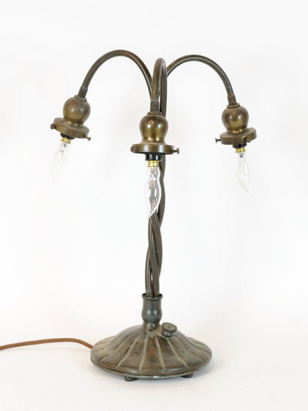 A TIFFANY STUDIOS GREEN PATINATED LAMP BASE, Americ: A TIFFANY STUDIOS GREEN PATINATED LAMP BASE, American, First Quarter Twentieth Century fashioned as three twisted arched stems with bulbous flared nozzles on domed fluted circular base, stamped on und