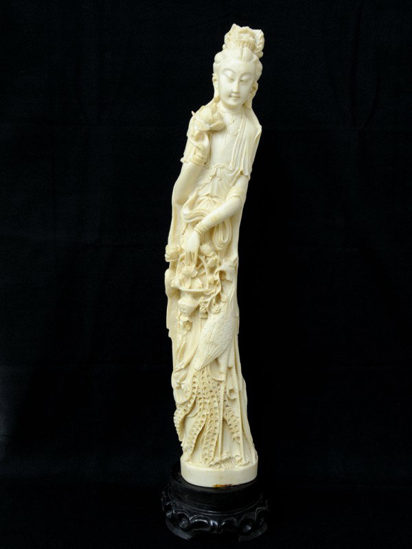 AN ASIAN COMPOSITION SCULPTURE OF A BUDDHIST GODDES: AN ASIAN COMPOSITION SCULPTURE OF A BUDDHIST GODDESS Holding a variety of Buddhist symbols and mounted on an Asian wood base. 26 x 6 x 6 inches