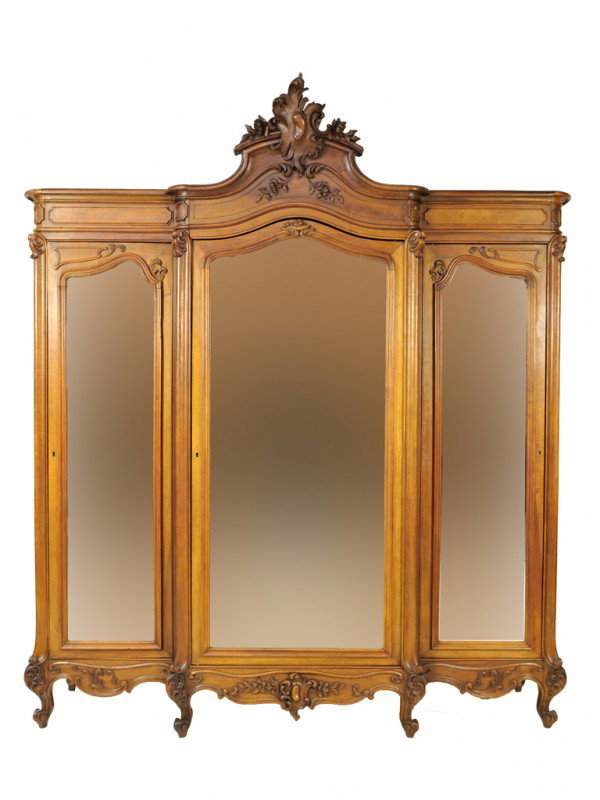A LOUIS XV WALNUT TRIPLE DOOR ARMOIRE: A LOUIS XV WALNUT TRIPLE DOOR ARMOIRE with three doors and mirrored panels, the central and largest with beveled glass mirror, with wooden shelves. a crack to the lower left corner of the left mirror 