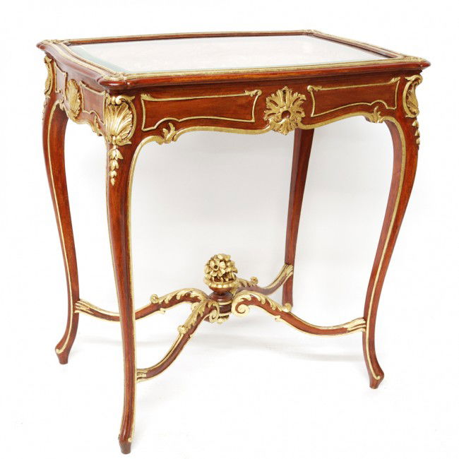A FINE LOUIS XV CARVED MAHOGANY AND GOLD LEAF TABL: A FINE LOUIS XV CARVED MAHOGANY AND GOLD LEAF TABLE VITRINE France Third Quarter Nineteenth Century the shaped inset beveled glass lift top reveals a tufted silk upholstered interior; the case on shel