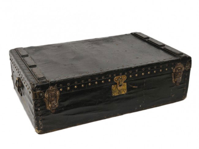 AN ANTIQUE LOUIS VUITTON TRUNK: AN ANTIQUE LOUIS VUITTON TRUNK a hard case with ebonized canvas covering the brass nail heads with Louis Vuitton imprint 11 x 36 x 22 inches