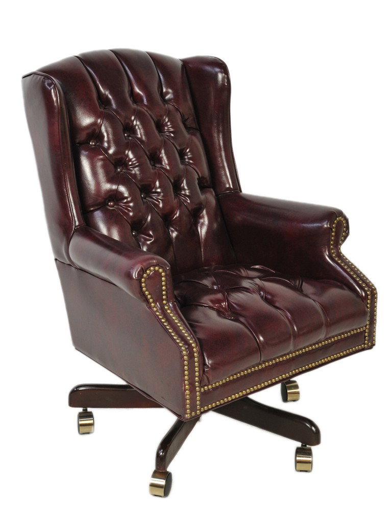 A MAROON LEATHER WING BACK ARM CHAIR FOR THE OFFIC: A MAROON LEATHER WING BACK ARM CHAIR FOR THE OFFICE with tufted back and seat; nail head trim; on swivel base with casters 40 x 26 x 18 inches