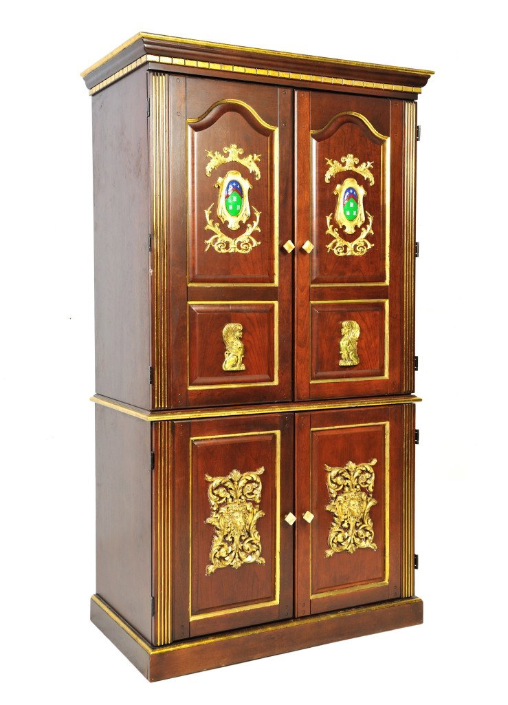 A PARCEL-GILT COMPUTER CABINET WITH POLYCHROME COAT: A PARCEL-GILT COMPUTER CABINET WITH POLYCHROME COAT-OF-ARMS Twentieth Century The flared cornice above the gilded dentilated frieze above two paneled cabinet doors each with a molded polychrome coat-o
