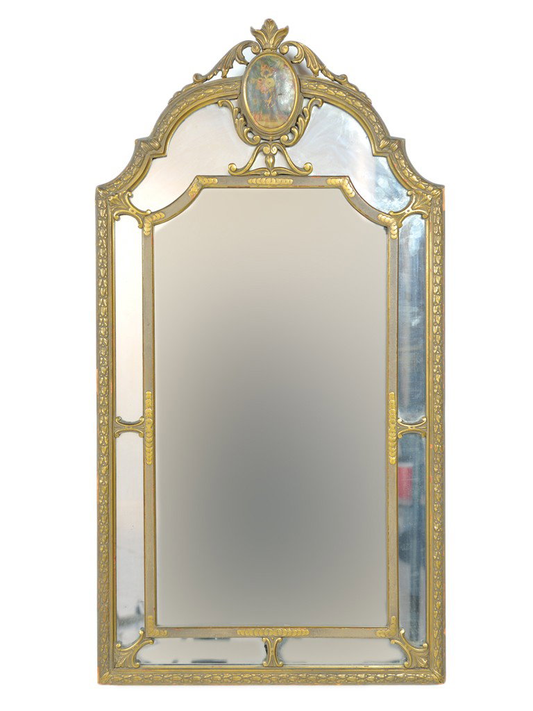 AN ANTIQUE NINETEENTH CENTURY GILDED MIRROR: AN ANTIQUE NINETEENTH CENTURY GILDED MIRROR the arched top with foliate crest surrounding a hand painted floral medallion; laurel leaf carved outer frame and scale accented inner frame; each frame con