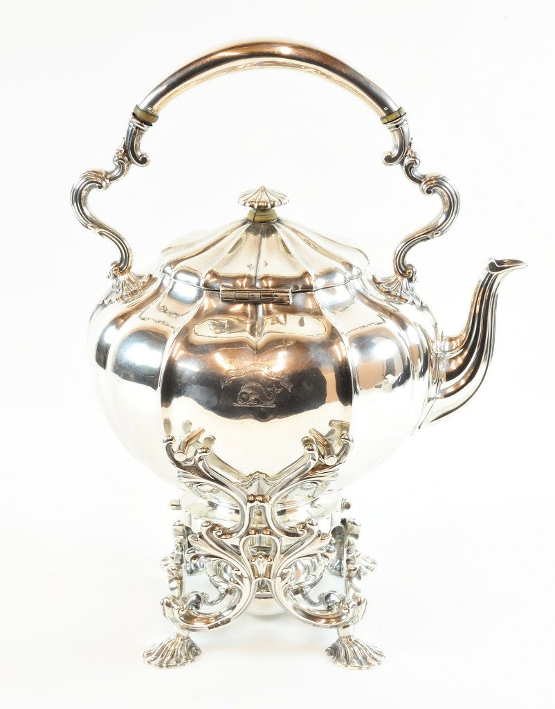 AN EARLY VICTORIAN STERLING SILVER WATER KETTLE ON BURN: AN EARLY VICTORIAN STERLING SILVER WATER KETTLE ON BURNER STAND Manufactured by Robert Garrard, London, England, 1841-42 The kettle having a lobed body engraved with a dolphin beneath a banner carryin