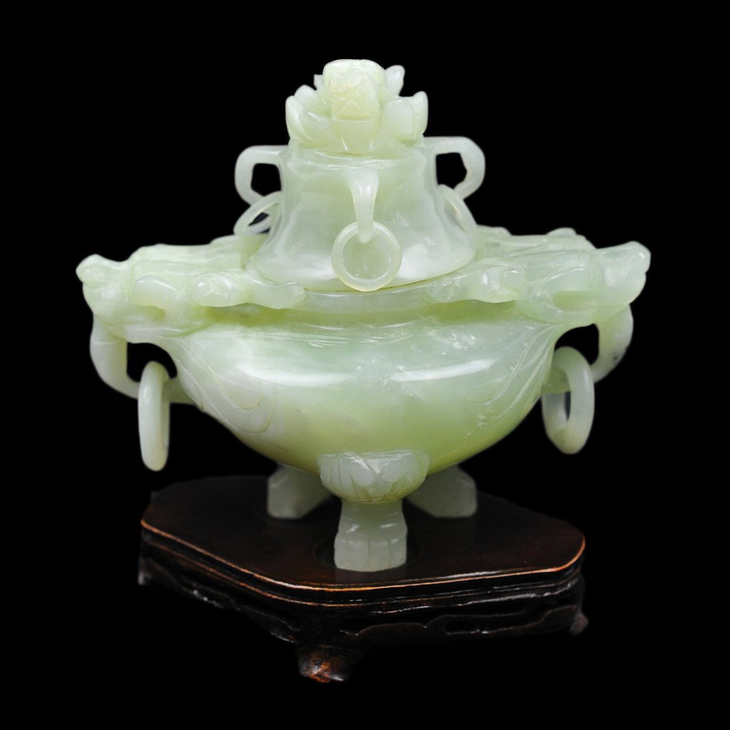A CHINESE CARVED JADE CENSER: A CHINESE CARVED JADE CENSER the lid with dragon head finial and three carved rings; the base with two dragon handles with carved rings; on tripodal carved paw feet; associated fitted stand 5 x 5 1/2 