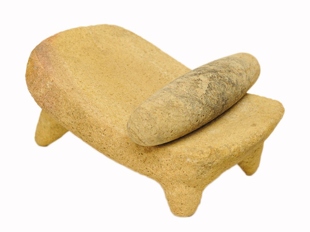 A STONE METATE AND MANO Possibly 550 - 950 A.D., G: A STONE METATE AND MANO Possibly 550 - 950 A.D., Guerrero, Mexico The three-legged metate having a roughly rectangular upper surface that curves down towards the user, made of rough yellowish tan volc