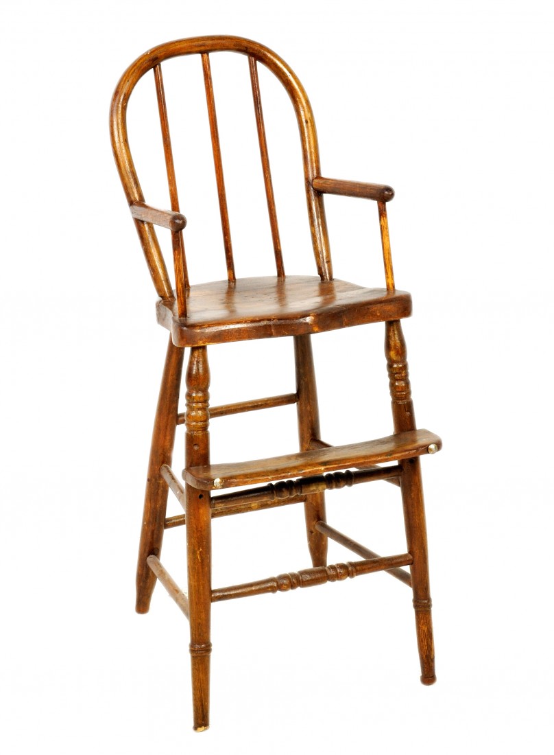 A WINDSOR CARVED ELM CHILD'S HIGH CHAIR, England,: A WINDSOR CARVED ELM CHILD'S HIGH CHAIR, England, mid - 19th Century the hoop back crestrail above a spindled back joined to the carved saddle seat by round arm rests on round supports raised on waist
