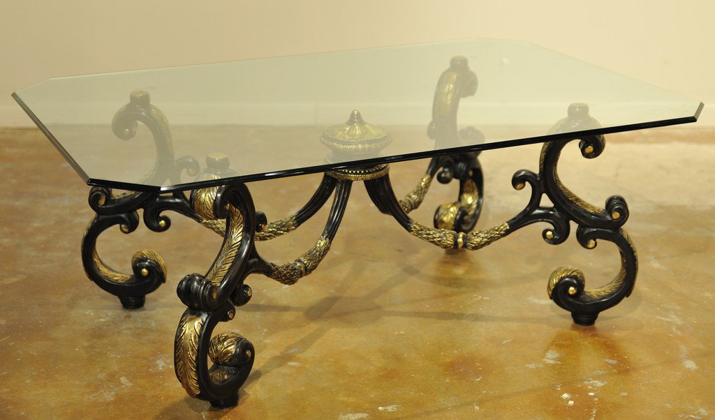 A BEVELED GLASS TOP COFFEE TABLE ON A METAL BASE WI: A BEVELED GLASS TOP COFFEE TABLE ON A METAL BASE WITH BLACK AND GOLD ACCENTS 20 1/2 x 54 56 inches