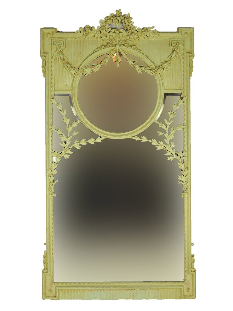 AN ORNATELY CARVED AND PAINTED VICTORIAN STYLE BEV: AN ORNATELY CARVED AND PAINTED VICTORIAN STYLE BEVELED MIRROR England, 1900 The pale spring green painted wood with festoon at crest and stepped corners with swags center circular beveled mirror above
