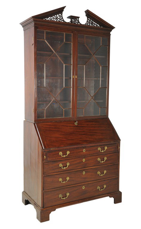 A GEORGE III STYLE MAHOGANY SLANT FRONT SECRETARY : A GEORGE III STYLE MAHOGANY SLANT FRONT SECRETARY 19th Century The broken pediment is supported by delicate pierced tracery and dentils. The complex cornice is supported by a rectilinear body with a p