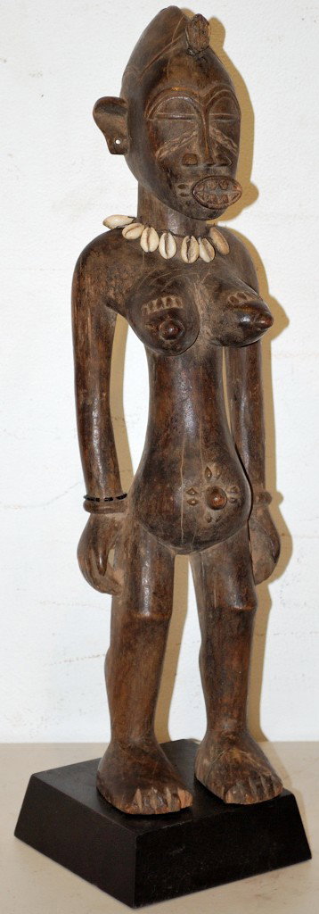 A SENUFO TRIBE WOOD CARVING - IVORY COAST: A SENUFO TRIBE WOOD CARVING - IVORY COAST Ritual statue of the Lo society used in initiations of novices. With a cowrie shell necklace. 20 x 5 x 5 inches